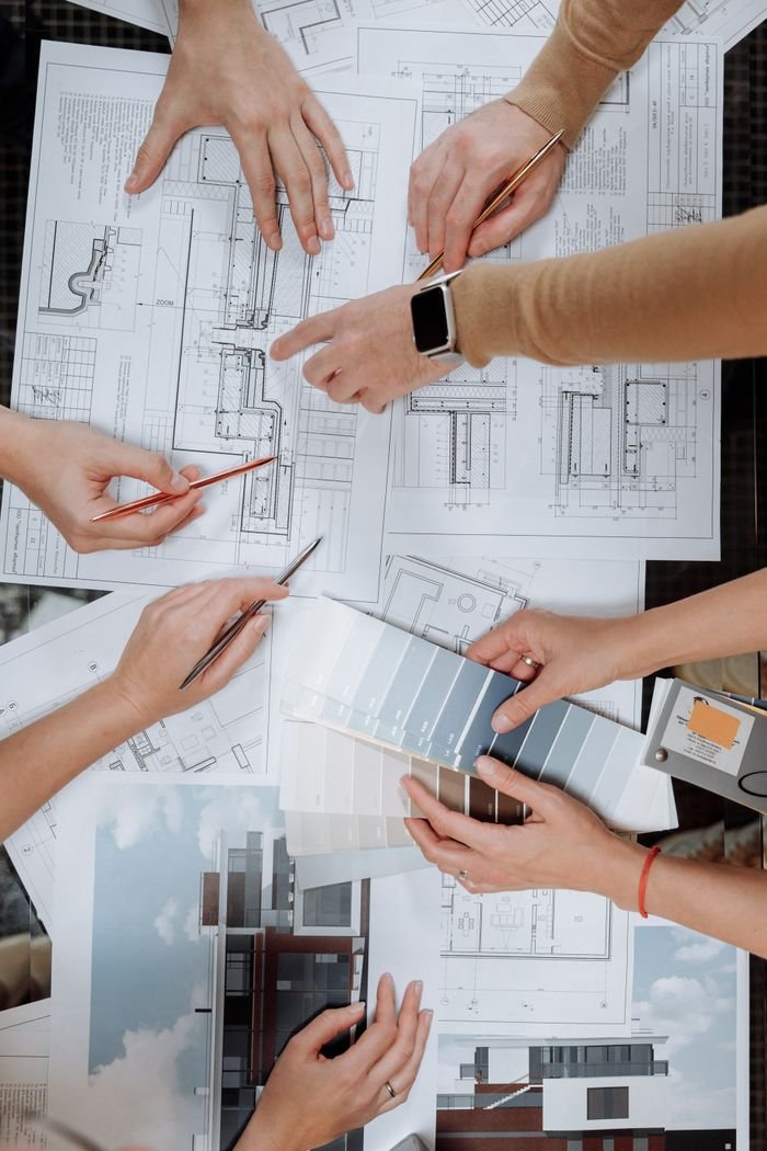 Team working together on architectural blueprints and color swatches.